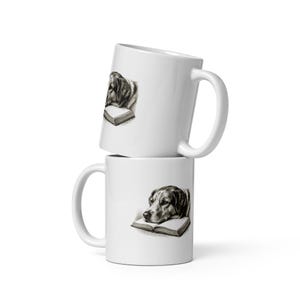 Op de afbeelding: Twee verticaal gestapelde witte keramische mokken. Elke mok is voorzien van een gedetailleerde zwart-witillustratie van een hond die zijn kop op een open boek laat rusten. De mokken hebben een gladde, glanzende afwerking met een zijhandvat.