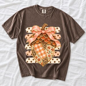 Giant patchwork acorn with a pink satin bow made of plaid, leopard and floral fabric on polka-dot stripes