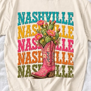 Pink embroidered cowboy boot with blooming cactus over a five-line stacked NASHVILLE word in retro colors