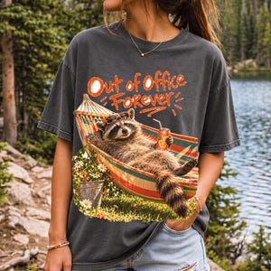 Raccoon relaxing in a hammock with a soda can and sunglasses, 90s film photo style, text "Out of Office Forever"