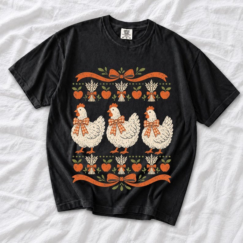 Three fluffy hens with gingham bows between apple and wheat borders, retro folk art fall t-shirt design