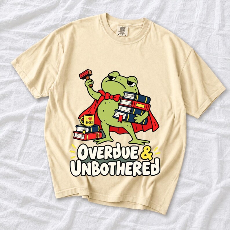 Grumpy cartoon frog librarian holding a stamp and a stack of books with the text Overdue & Unbothered