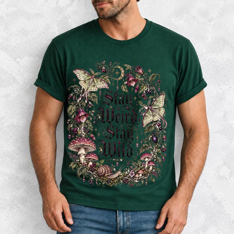 Victorian-style wreath of nightshade, luna moths and toadstools around the words "Stay Weird, Stay Wild"