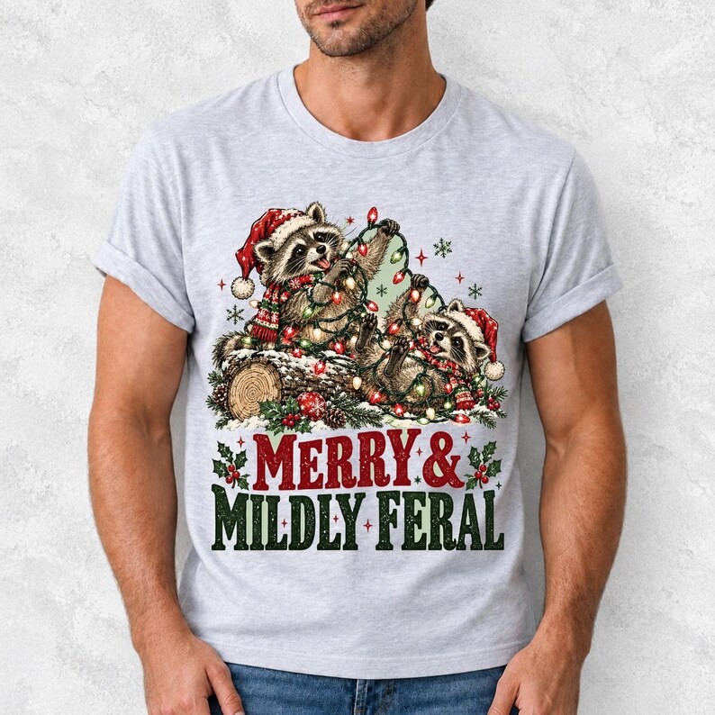 Two raccoons tangled in Christmas lights beside a log with the text Merry & Mildly Feral