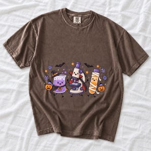Kawaii beaker, microscope and test tube with faces in Halloween costumes, pastel purple and orange