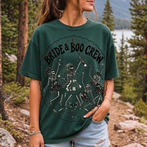 Skeleton bride popping champagne with cheering skeleton bridesmaids and the text Bride & Boo Crew