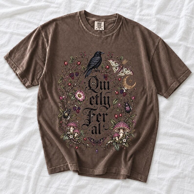 Raven on a wild rose branch with beetles and berries around blackletter text "Quietly Feral"