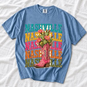 Pink embroidered cowboy boot with blooming cactus over a five-line stacked NASHVILLE word in retro colors