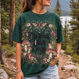 Blackletter text "Mushroom Witch Society" framed by fly agaric mushrooms, ferns and a toad on a mushroom cap