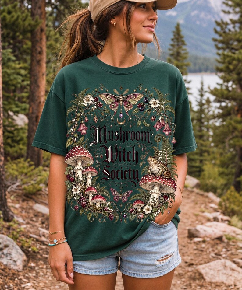 Blackletter text "Mushroom Witch Society" framed by fly agaric mushrooms, ferns and a toad on a mushroom cap