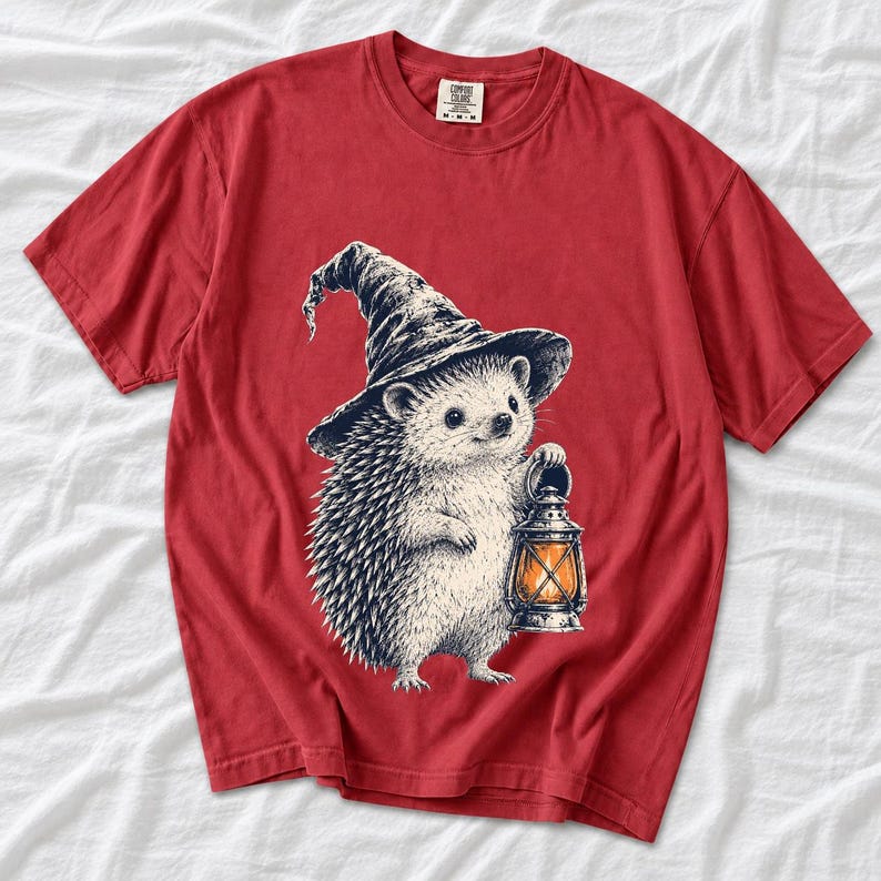 Etched pen illustration of a hedgehog in a witch hat holding a lantern, bone white with orange accent
