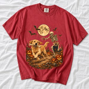 A skeleton chasing a golden labrador that stole its arm bone under a full moon with jack o lanterns and bats