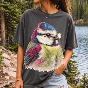 Colored-pencil blue tit bird wearing tiny round reading glasses, funny birdwatcher t-shirt illustration
