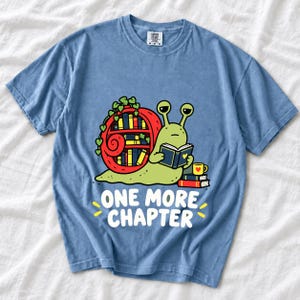 Cartoon snail reading a book with a bookshelf shell and the text One More Chapter