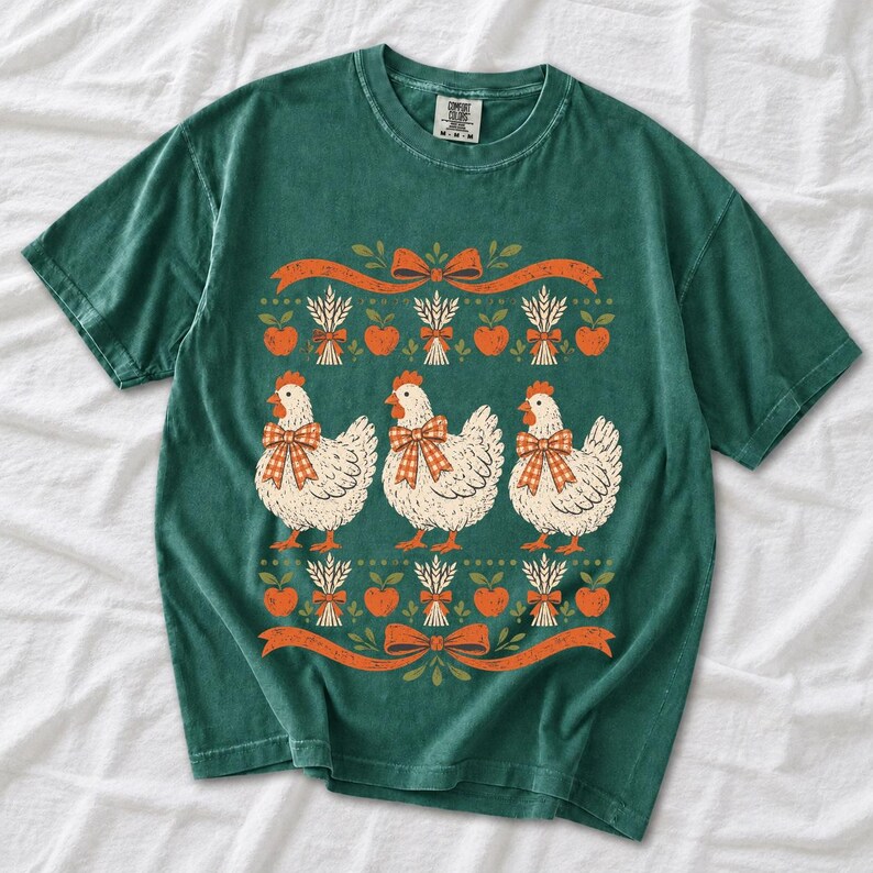 Three fluffy hens with gingham bows between apple and wheat borders, retro folk art fall t-shirt design