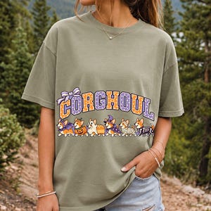 Six corgis in Halloween costumes walking under the arched word CORGHOUL, lavender and orange polka-dot varsity style