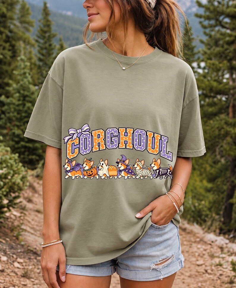 Six corgis in Halloween costumes walking under the arched word CORGHOUL, lavender and orange polka-dot varsity style