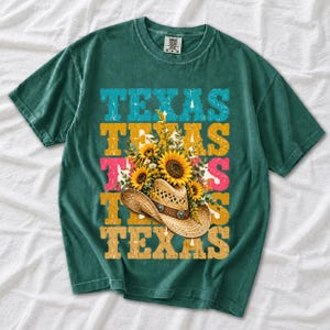Straw cowboy hat full of sunflowers over a five-line stacked TEXAS word in retro western colors