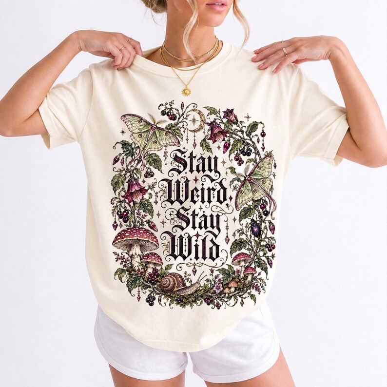 Victorian-style wreath of nightshade, luna moths and toadstools around the words "Stay Weird, Stay Wild"