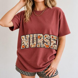 Arched varsity word NURSE filled with autumn leaves, stethoscopes and pumpkins in cream, rust and mustard