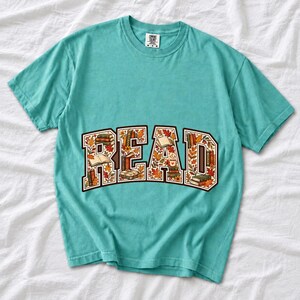 Arched varsity word READ filled with tiny books and autumn leaves in cream, rust and mustard