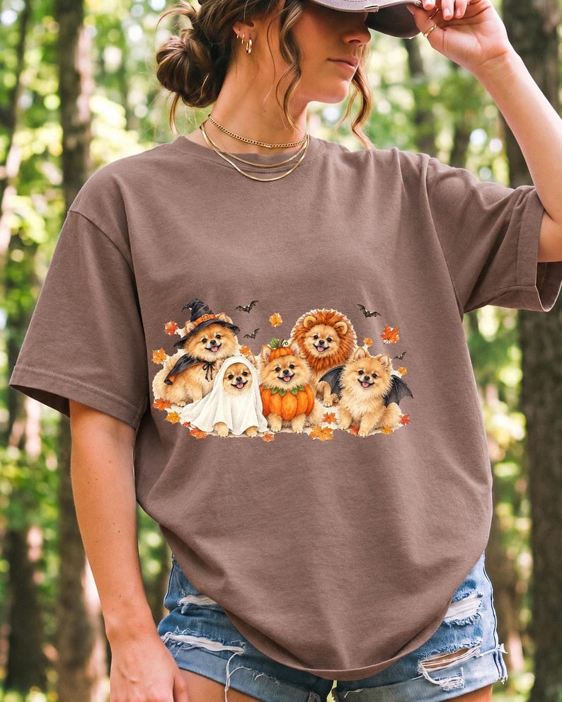 Five fluffy watercolor pomeranians in Halloween costumes with autumn leaves and bats