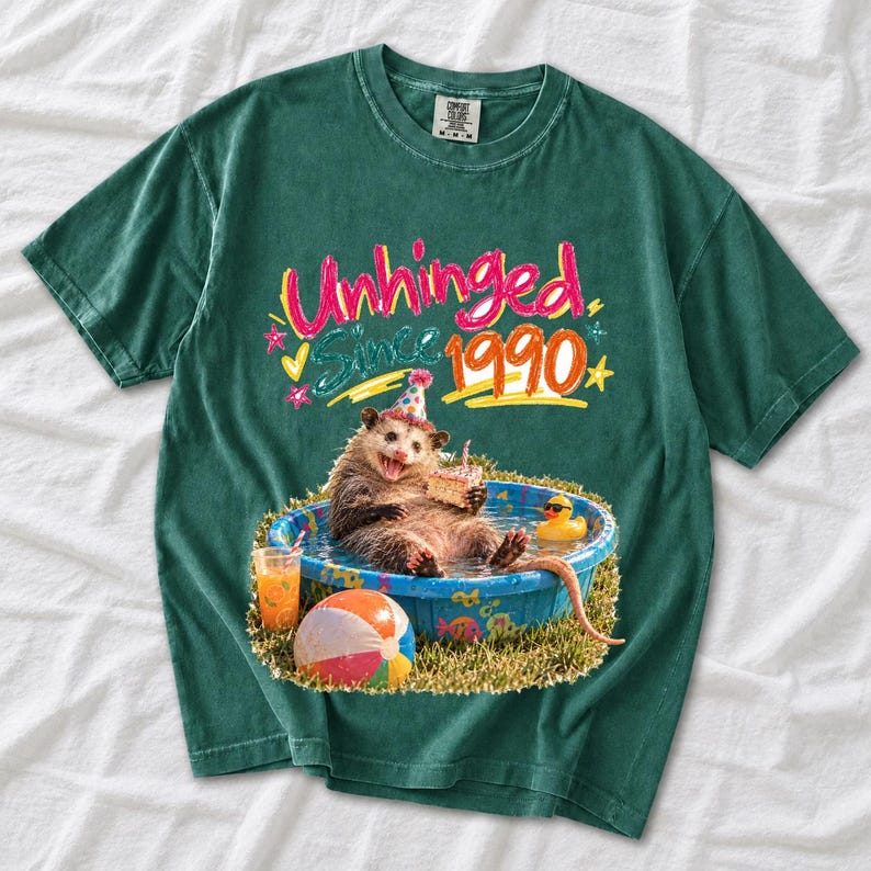 Opossum in party hat in a kiddie pool with cake, 90s film photo style, text "Unhinged Since 1990"