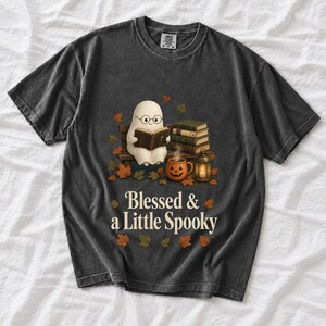 Cute ghost with glasses reading a Bible with a candle and mug, text "Blessed & a Little Spooky", retro fall illustration