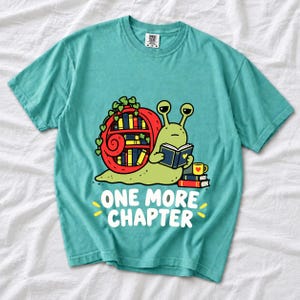 Cartoon snail reading a book with a bookshelf shell and the text One More Chapter