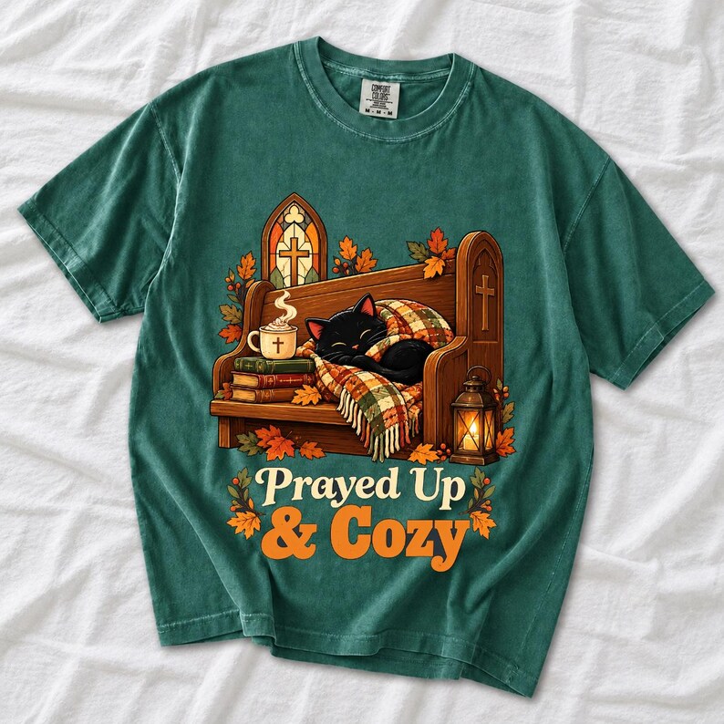 Black cat curled on a church pew with blanket and cocoa among autumn leaves, text "Prayed Up & Cozy", retro illustration