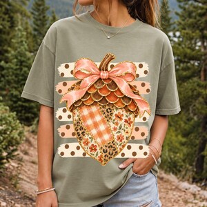 Giant patchwork acorn with a pink satin bow made of plaid, leopard and floral fabric on polka-dot stripes
