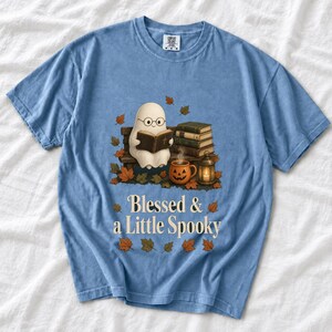Cute ghost with glasses reading a Bible with a candle and mug, text "Blessed & a Little Spooky", retro fall illustration
