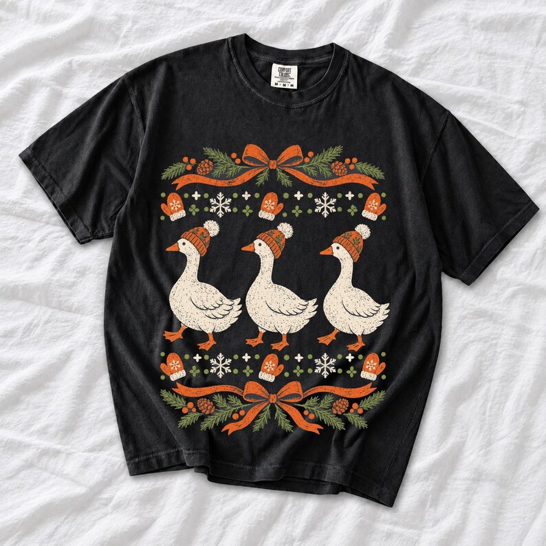 Three geese in pompom knit beanies with mittens, snowflakes and pine borders, retro winter t-shirt graphic