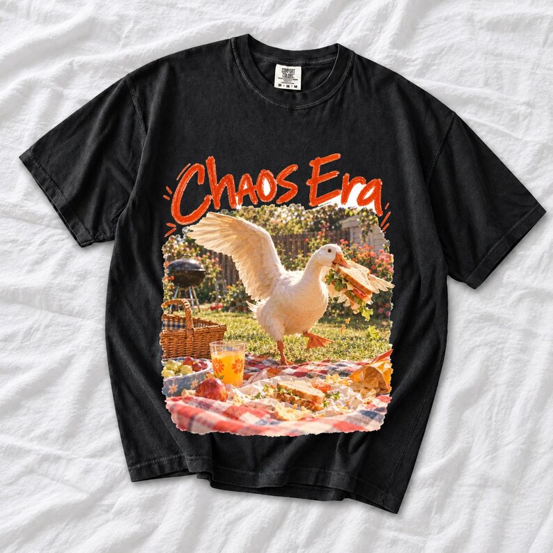 Goose stealing a sandwich from a picnic blanket, 90s film photo style, text "Chaos Era"