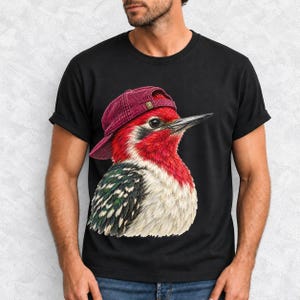 Colored-pencil red-headed woodpecker in side profile wearing a backwards corduroy cap, funny birder t-shirt graphic