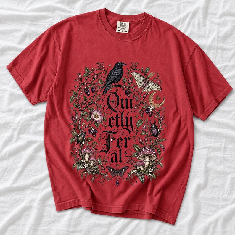 Raven on a wild rose branch with beetles and berries around blackletter text "Quietly Feral"