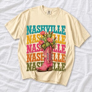 Pink embroidered cowboy boot with blooming cactus over a five-line stacked NASHVILLE word in retro colors