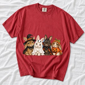 Realistic illustration of four bunnies in witch, ghost, vampire cape and pumpkin costumes in a row