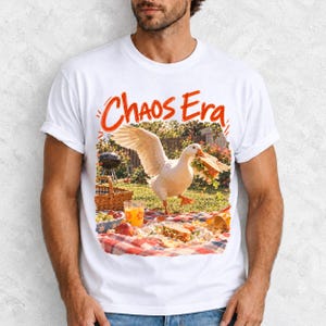 Goose stealing a sandwich from a picnic blanket, 90s film photo style, text "Chaos Era"