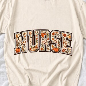 Arched varsity word NURSE filled with autumn leaves, stethoscopes and pumpkins in cream, rust and mustard