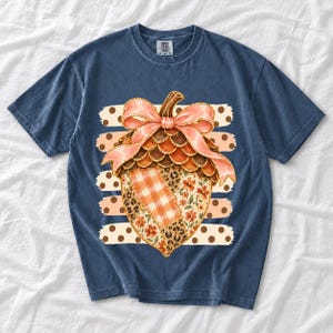 Giant patchwork acorn with a pink satin bow made of plaid, leopard and floral fabric on polka-dot stripes