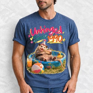 Opossum in party hat in a kiddie pool with cake, 90s film photo style, text "Unhinged Since 1990"
