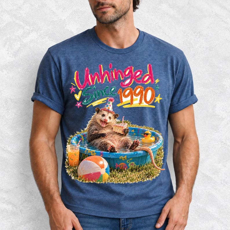 Opossum in party hat in a kiddie pool with cake, 90s film photo style, text "Unhinged Since 1990"