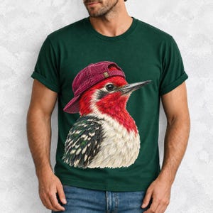 Colored-pencil red-headed woodpecker in side profile wearing a backwards corduroy cap, funny birder t-shirt graphic