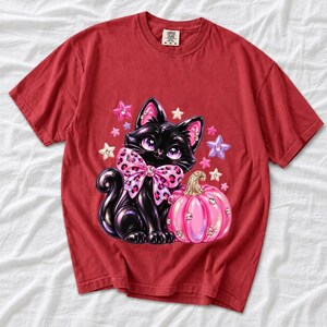 Puffy 3D black cat with a leopard bow beside a glossy pumpkin and stars in coquette style