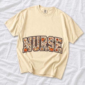 Arched varsity word NURSE filled with autumn leaves, stethoscopes and pumpkins in cream, rust and mustard