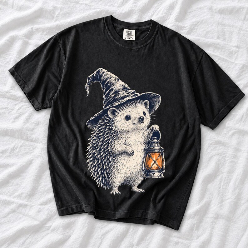Etched pen illustration of a hedgehog in a witch hat holding a lantern, bone white with orange accent