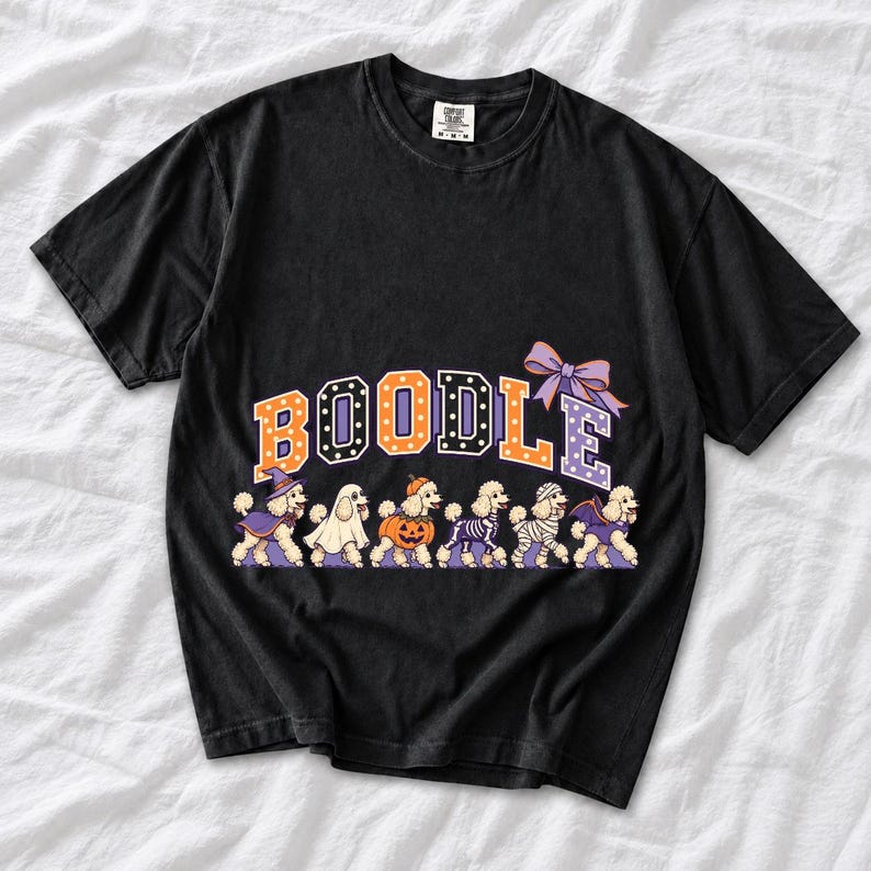 Six poodles in Halloween costumes walking under the arched word BOODLE, lavender and orange polka-dot varsity style