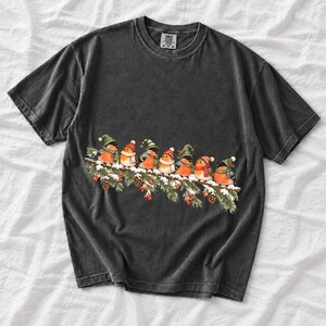 Watercolor bullfinches and robins in elf hats and scarves on a snowy pine branch
