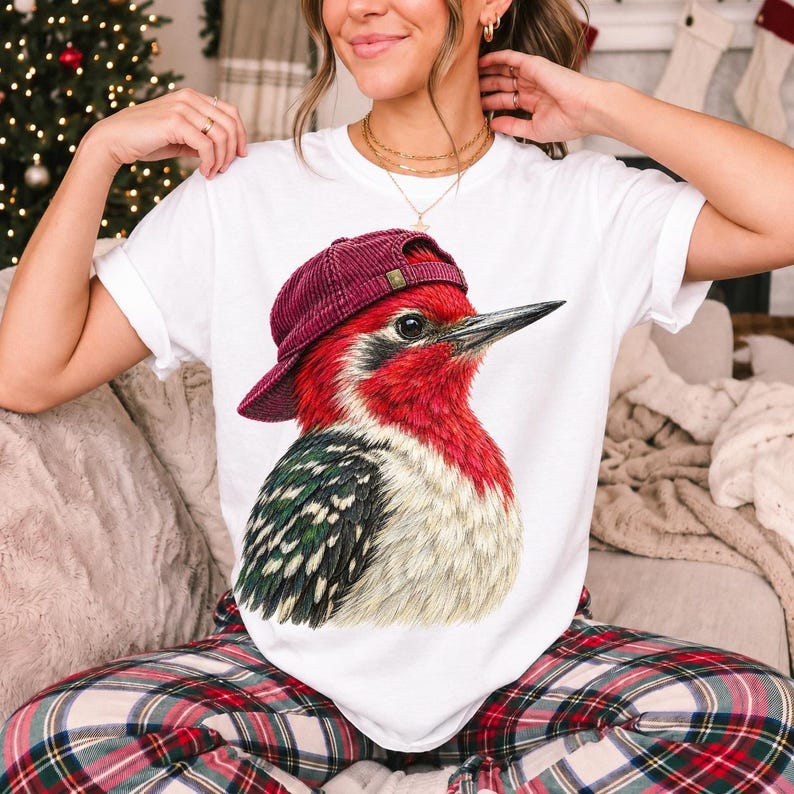 Colored-pencil red-headed woodpecker in side profile wearing a backwards corduroy cap, funny birder t-shirt graphic